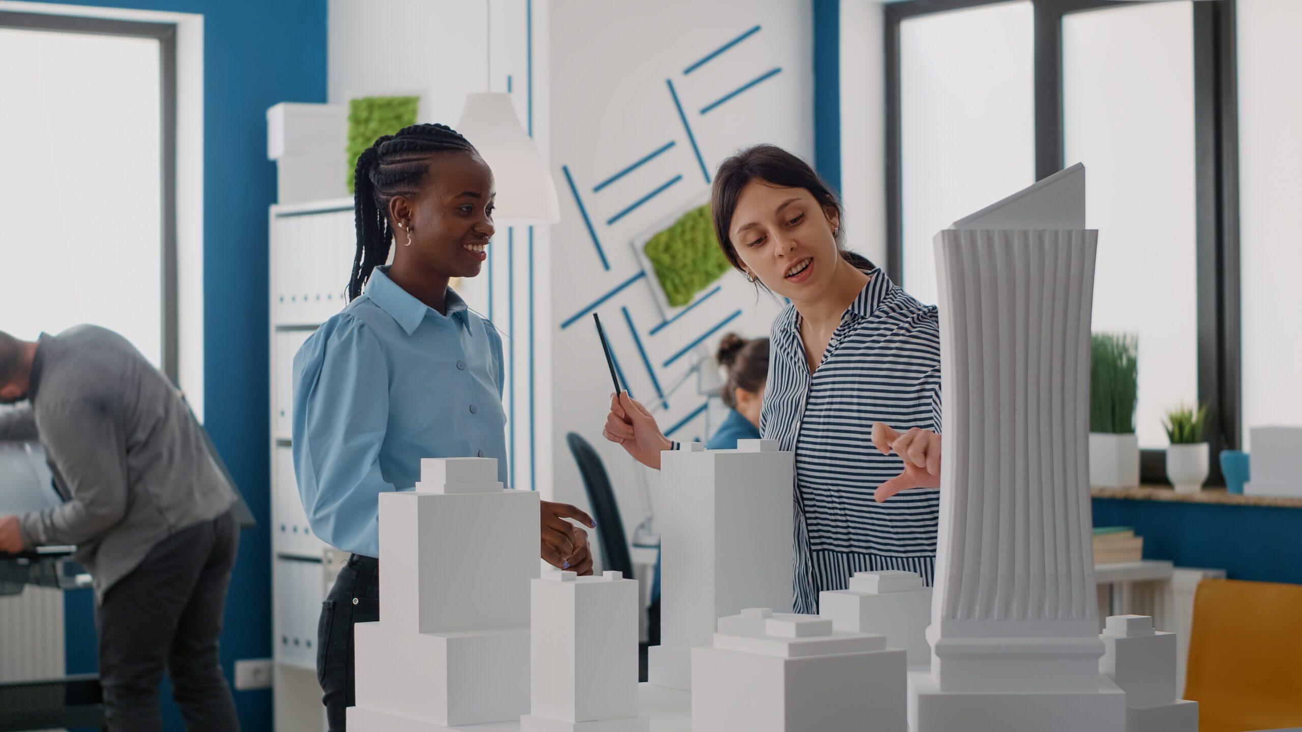 Architect looking at building model