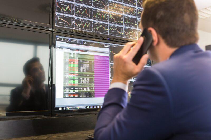 Stock trader looking at computer screens